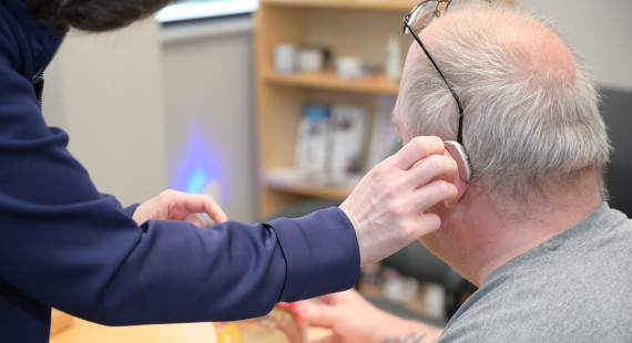 A male patient getting fitted for a hearing aid