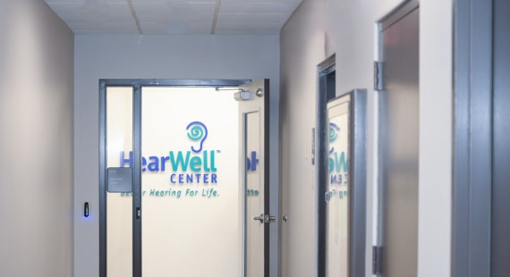 The HearWell Center logo on the wall at the end of the hall